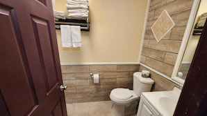 A bathroom with a toilet, sink, and towel rack. - Starlite Motor Inn (Absecon)