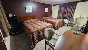A hotel room with two beds, a desk, a chair, a lamp, and a window with curtains. - Starlite Motor Inn (Absecon)