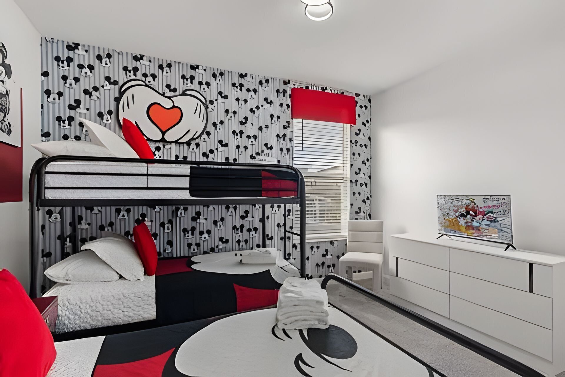 A modern bedroom with a bunk bed, a desk, and a chair.