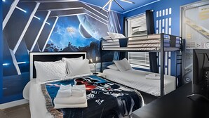 Une chambre moderne avec un lit superposé, une grande fresque murale et un luminaire au plafond original.