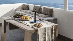 A balcony with a view of the sea, a table with food and drink, and a cushioned seating area. - Hiera - Two Bedroom Villa, Sleeps 4 (Marettimo)