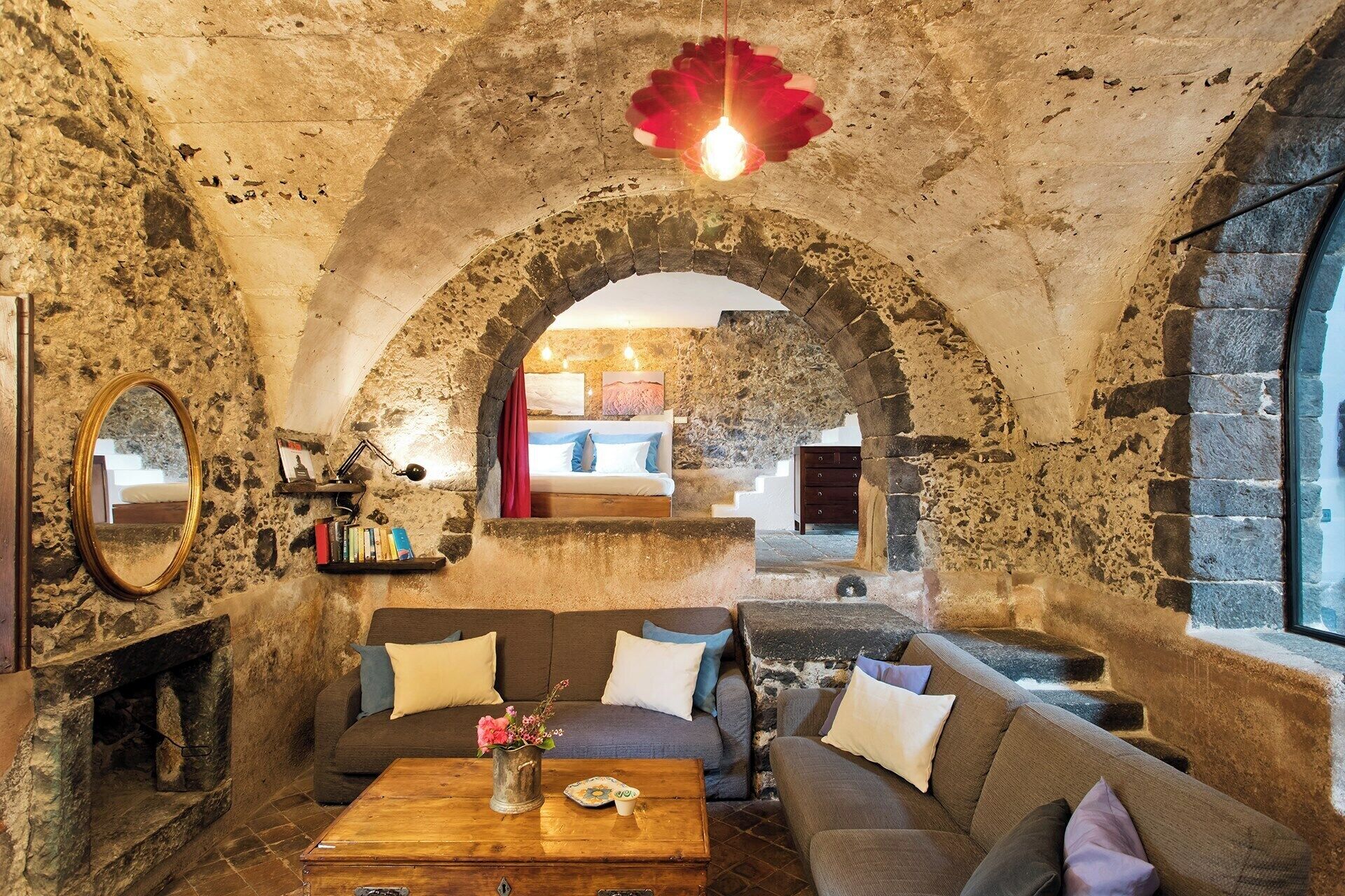 A cozy room with stone walls, a wooden coffee table, and a sofa.