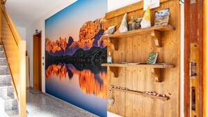 Una zona de recepción con un escritorio de madera, un mural panorámico y una escalera.