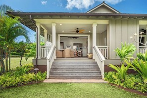 Ein Haus mit einer Veranda, Treppen zu einem überdachten Bereich und Blick ins Innere.