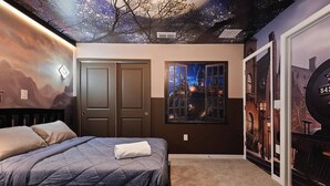 Ein Schlafzimmer mit Bett, Tür und Wand mit Wandmalerei.