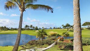 A hammock between palm trees overlooking a golf course with a lake. - Ocean Views | Plunge Pool & Fire Pit | Villa + Guesthouse (Koloa)