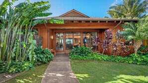 A modern house with a wooden facade, large windows, and a well-maintained garden with tropical plants. - Ocean Views | Resort Amenities | Plunge Pool & Guesthouse (Koloa)