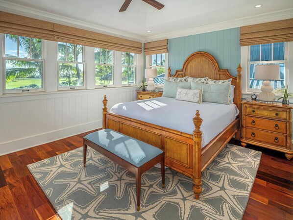 A bedroom with a large bed, wooden headboard, and a nightstand with a lamp.