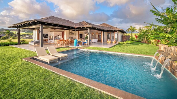 Una casa moderna con piscina, mobili da esterno e una zona patio coperta.