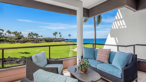 A balcony with a view of a golf course and the ocean. - Modern & Renovated Mauna Lani Point F204 | Ocean Views | Professionally Managed (Kamuela)