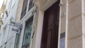 Un edificio con una porta in legno scuro, dettagli architettonici elaborati e una segnaletica che indica una struttura medica.