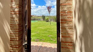 An open brick archway leading to a grassy yard with a clear sky and a tree. - Casa Fresno country lodging for up to 5 people near Salamanca (ALMENARA DE TORMES)