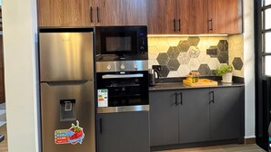 Een moderne keuken met houten kastjes, roestvrijstalen apparatuur en een backsplash van hexagontegels.