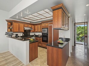Uma cozinha moderna com armários de madeira, uma ilha central e vista para o exterior.