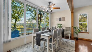 Un espace repas comprenant une grande table, des chaises et un ventilateur de plafond.