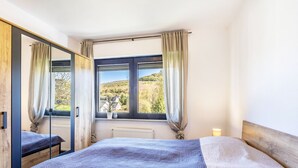 Una camera da letto con un letto grande, una finestra vista paesaggio e uno specchio.
