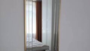 A hotel room with a large mirror, a bed, and a window. - London Serenity House - 4 Bedrooms (London)