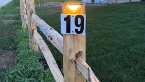 Une clôture en bois sur laquelle est affiché un panneau indiquant le numéro 19.