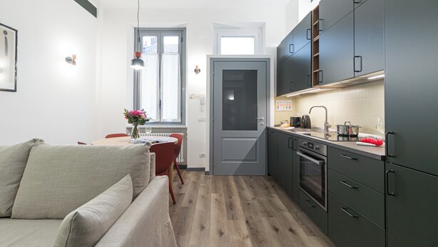 Un appartamento moderno con soggiorno, sala da pranzo e cucina.