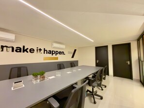 A conference room with a long table, chairs, an air conditioning unit, and a motivational wall quote. - Move Tambau 108 (João Pessoa)