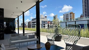 A modern outdoor seating area with a view of the city skyline.