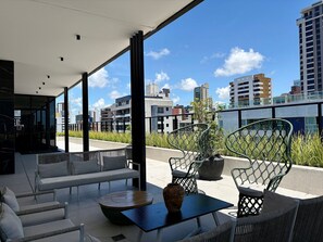 A modern outdoor seating area with a view of the city skyline. - Move Tambau 108 (João Pessoa)