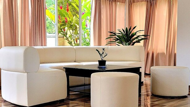 A modern living room with a sofa, ottoman, and coffee table. - Villa Los Rios (Pedro Brand)