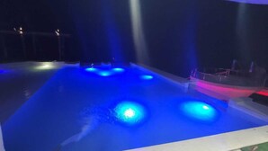A swimming pool with blue lighting and a small boat. - Villa Los Rios (Pedro Brand)