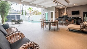 A spacious living area with a pool, dining set, and a kitchen area. - Blue House (Rio de Janeiro)