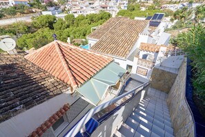 Ein Wohngebiet mit terrakottafarbenen Dächern, einer Satellitenschüssel und einer Treppe, die zu einem Balkon führt.