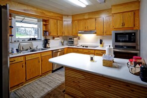 Una cocina moderna con armarios de madera, electrodomésticos de acero inoxidable y una isla grande.