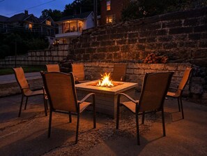 An outdoor seating area with a square fire pit surrounded by six chairs. - The Lodge at Welch - Both the Big and Little House (Welch)
