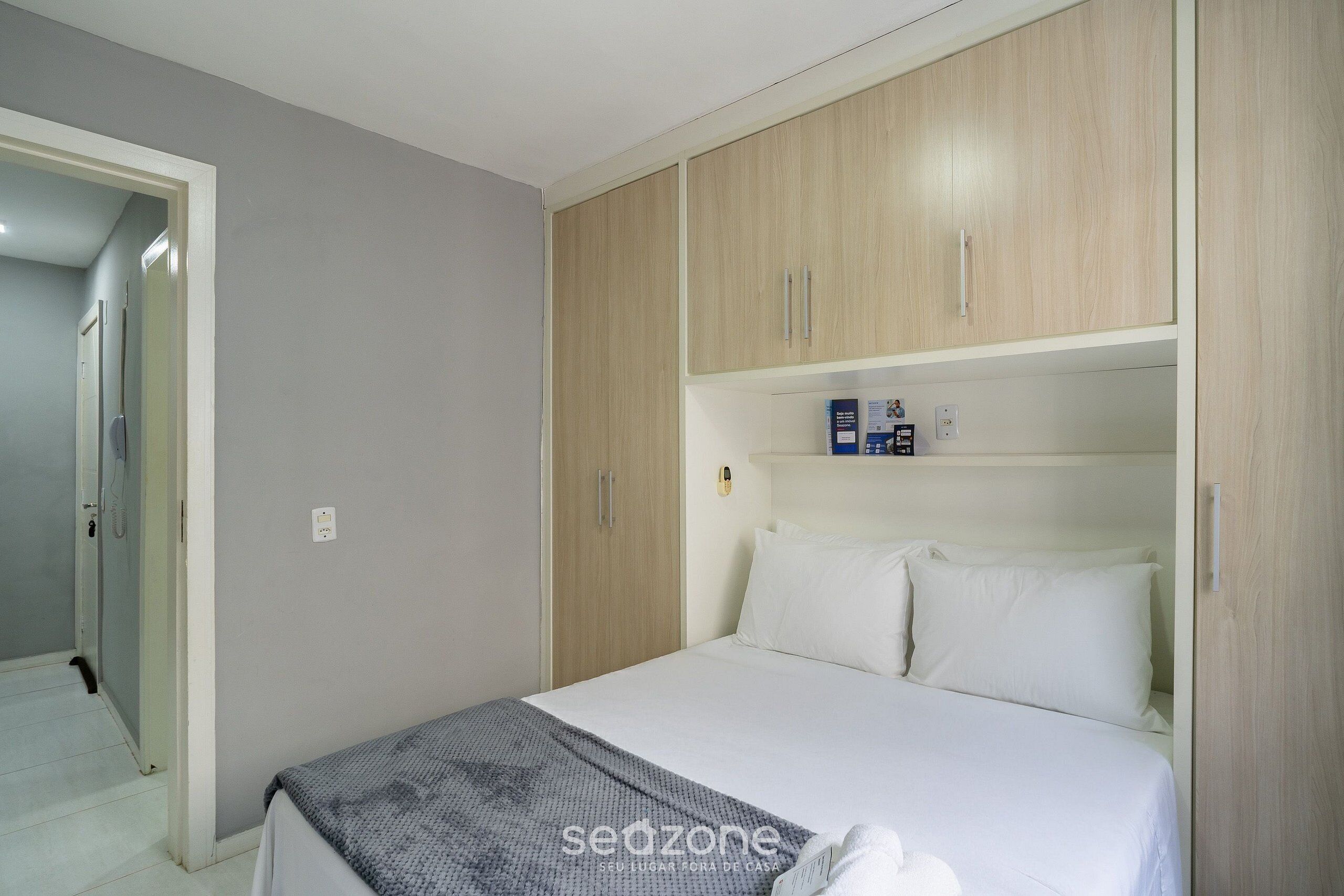 A bedroom with a bed, a wardrobe, and a door to a bathroom.