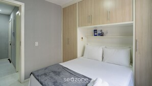 Une chambre à coucher avec un lit, une armoire et une porte donnant sur une salle de bain.