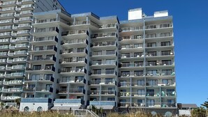 Ein mehrstöckiges Hotel mit Balkonen, Blick auf den Strand und moderner Architektur.