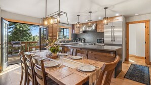 Una cocina moderna con una isla grande, electrodomésticos de acero inoxidable e iluminación colgante.