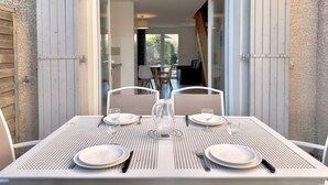 A dining table set for two with white plates, cutlery, and a pitcher, positioned at the entrance of a building with a number sign 'N108'. - Les Deux Terrasses, 6 guests, Pool in Calvisson (Calvisson)