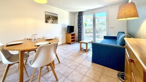 A dining area with a table, chairs, and a television in the background. - Les Deux Terrasses, 6 guests, Pool in Calvisson (Calvisson)
