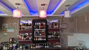 Zona de bar con estantes llenos de botellas de licor, una caja registradora y un cartel que indica un precio de 35.