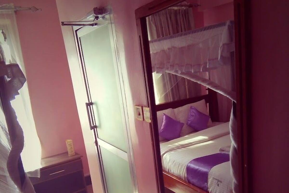 Una habitación con literas, un armario y una cama con dosel.