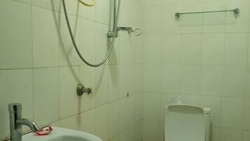 Un baño pequeño con lavamanos, inodoro y ducha.