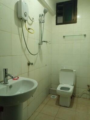 Un baño pequeño con lavamanos, inodoro y ducha.