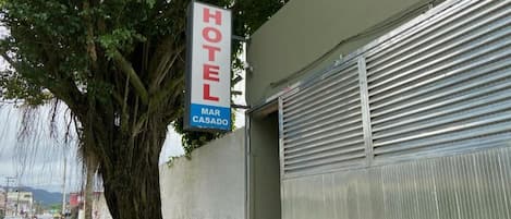 A hotel sign with the name "MAR CASADO" and a closed metal shutter door.