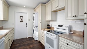 A kitchen with white cabinets, a stove, and a washing machine. - Spacious 3BR Condo w/ Private Off-Street Parking for 3 Vehicles! (Vestavia Hills)