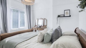 A bedroom with a wooden bed, a dresser, a mirror, and a window with blinds. - Taf Fechan - 3 Bedroom House - Pontsticill (Merthyr Tydfil)