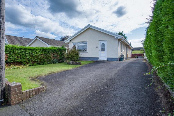 A single-story house with a white exterior and a grey driveway. - Cefn Road - 3 Bedroom Bungalow - Glais (Swansea)