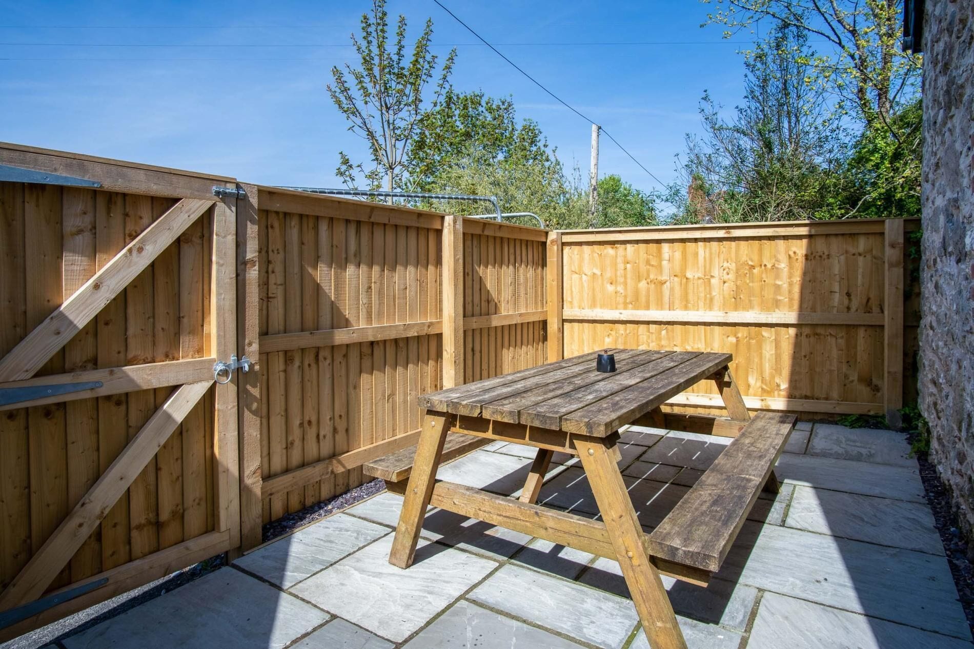 A wooden deck with a picnic table and a gate.