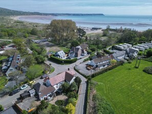 A coastal village with houses, a beach, and a clear view of the sea. - Bullcroft - 6 Bedroom House - Oxwich (Swansea)
