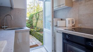 A modern kitchen with a built-in oven, a sink, and a toaster. - Sea Breeze Apt 1 - 1 Bedroom - Horton Beach (Swansea)