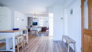 Una cocina amplia con comedor, piso de madera y una pared de acento de piedra.